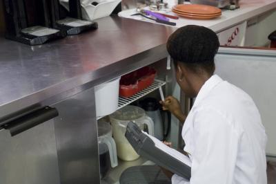 Inspecting temperature of restaurant refrigerator