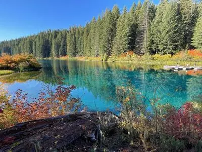 Rowboat on a very blue lake with fall leaves