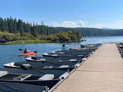 kayaker paddling past rowboats at the dock
